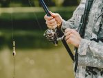 A man fishing on a lake. Guy in a uniform.