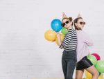pretty-teenage-girls-standing-back-back-holding-colorful-balloons-hand